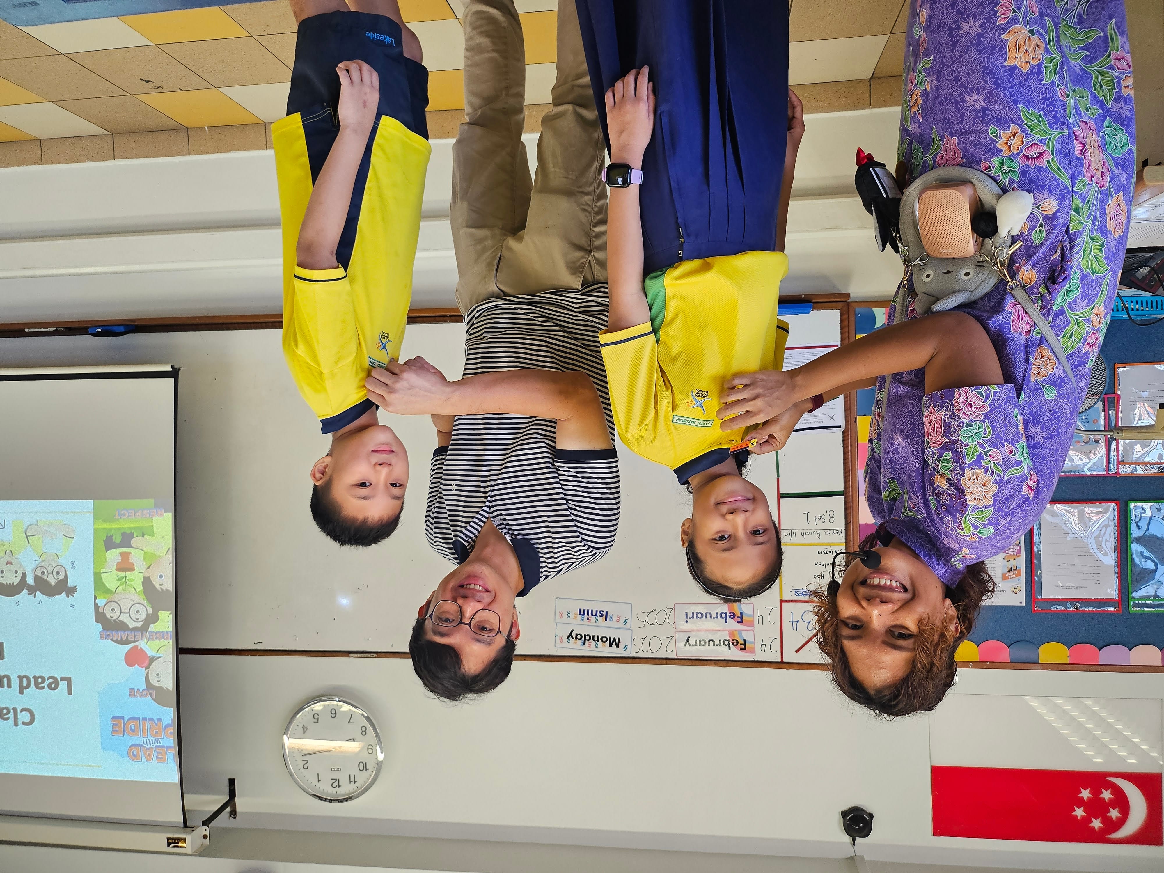 Classroom scenes showing young students in yellow uniforms receiving a pin from their teachers